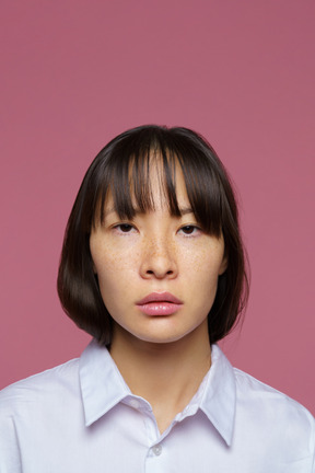 Vue de face d'une jeune femme sérieuse en bref regardant la caméra