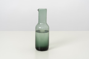 A glass bottle of cold water, designed in a simple style and form