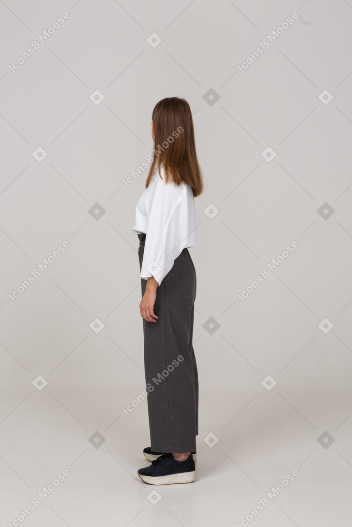 Vista laterale di una giovane donna in abiti da ufficio che guarda a destra