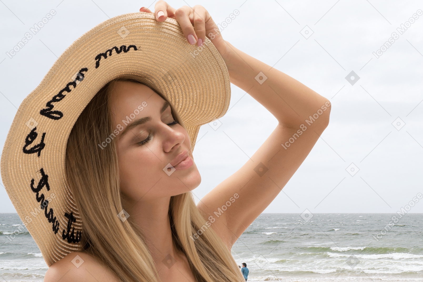 ビーチでリラックスした帽子をかぶった至福の女性