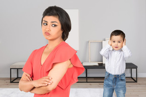 A woman standing next to a toddler in a living room