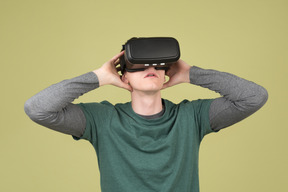 Изумленный молодой человек в комплекте виртуальной реальности