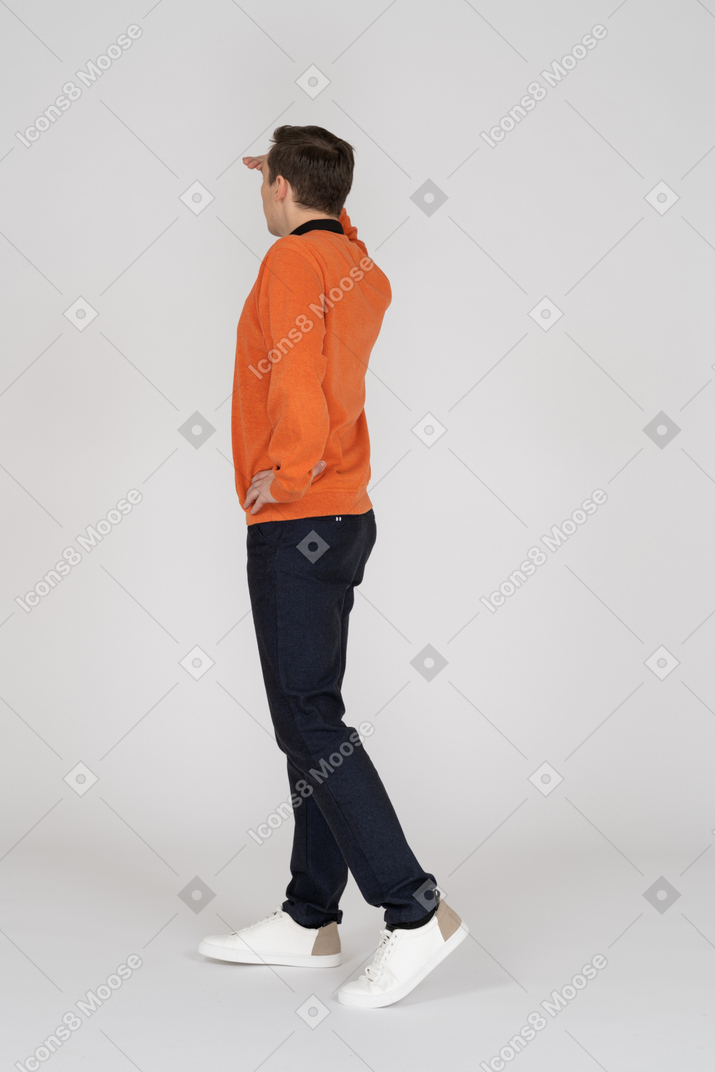 Young man in orange sweatshirt standing