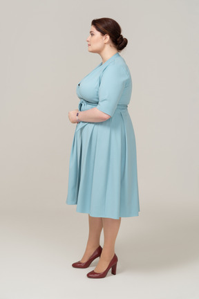 Femme en robe bleue debout de profil