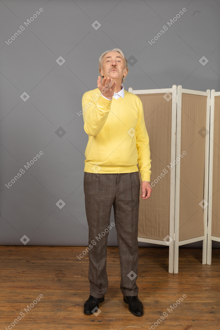 Front view of an old man sending an air kiss