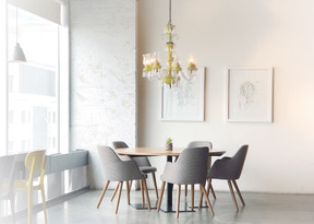 Light-filled room with a round table and a few chairs