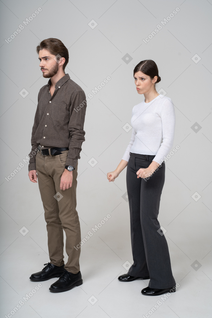 郁闷的年轻夫妇，在办公室服装中的四分之三的视图