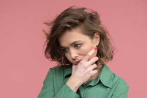 Concerné femme brune debout profondément dans ses pensées