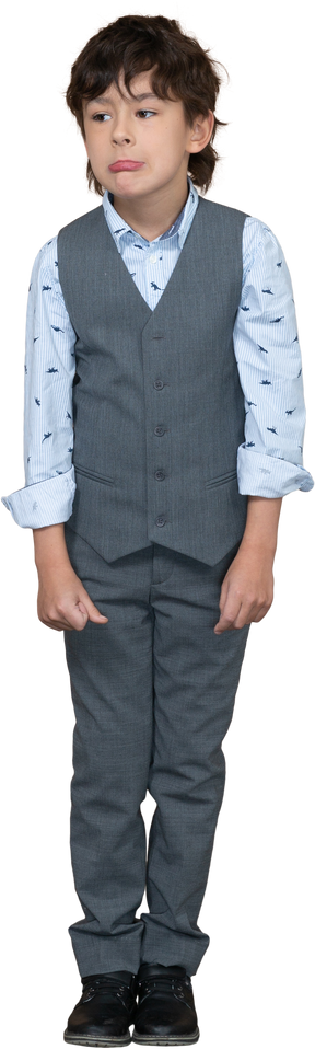 Vista frontale di un ragazzo in abito grigio che fa le smorfie
