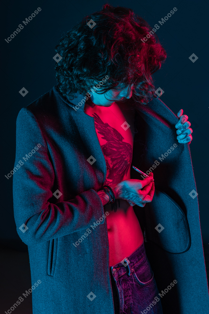 Young man taking cigarette out of jacket