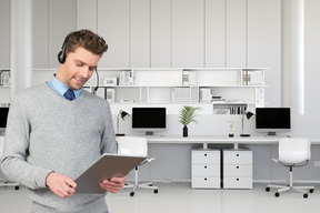 A man wearing a headset looking at a tablet