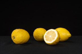 Quattro limoni che giacciono sullo sfondo nero