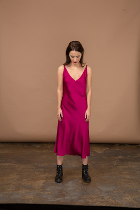 Front view of a young woman in beautiful red dress looking down