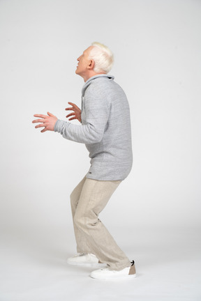 Side view of a man with bent knees looking up