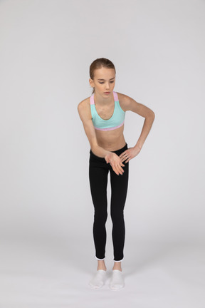 Вид сбоку девушки-подростка в спортивной одежде, поднимающей руку и спорящей