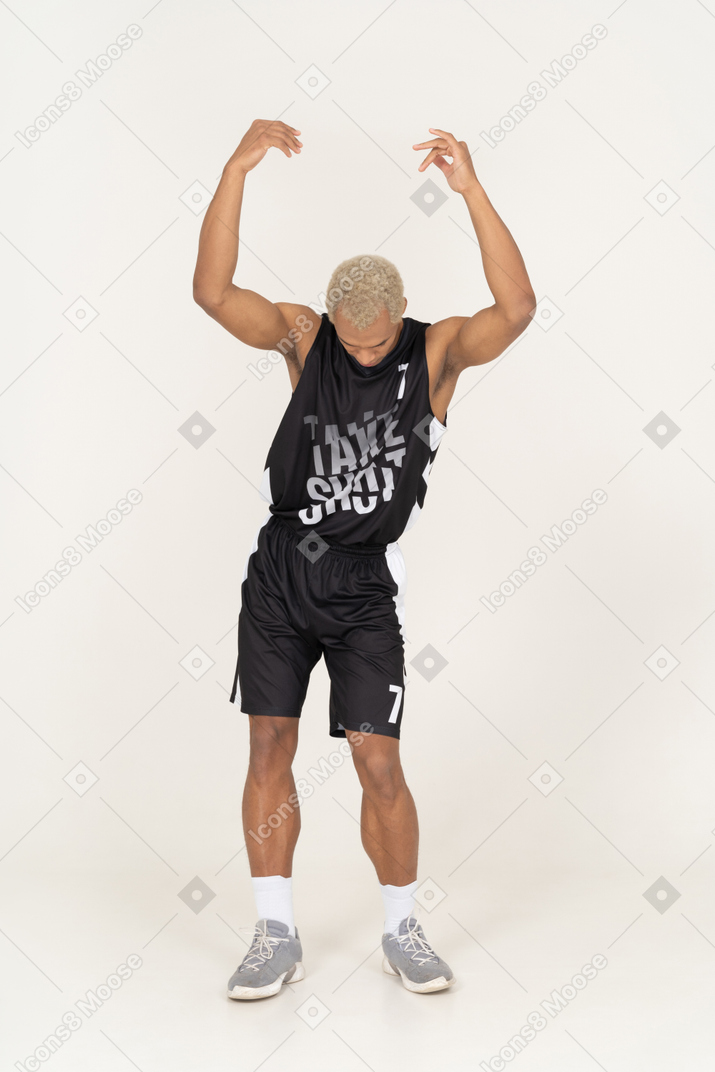 見下ろしながら手を上げる若い男性バスケットボール選手の正面図