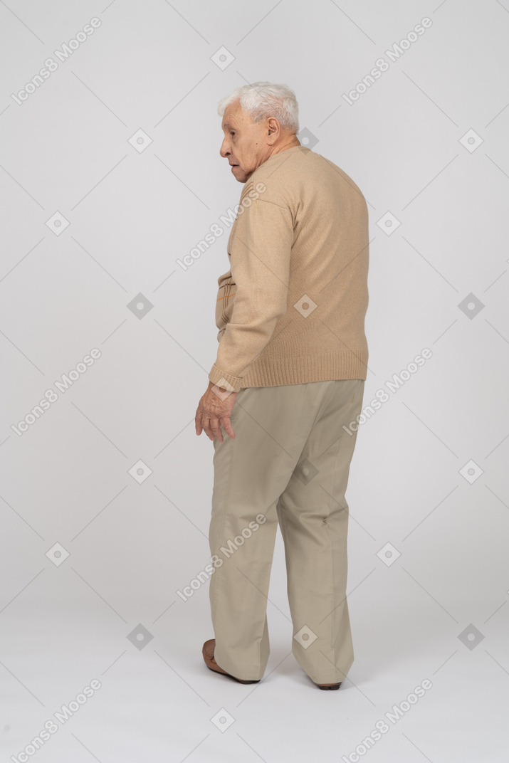 Вид сзади на старика в повседневной одежде, идущего