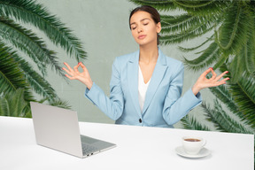Женщина-офисный работник медитирует на рабочем месте