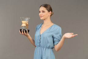 四分之三的视角，一名身穿蓝色连衣裙的年轻女子拿着一壶酒