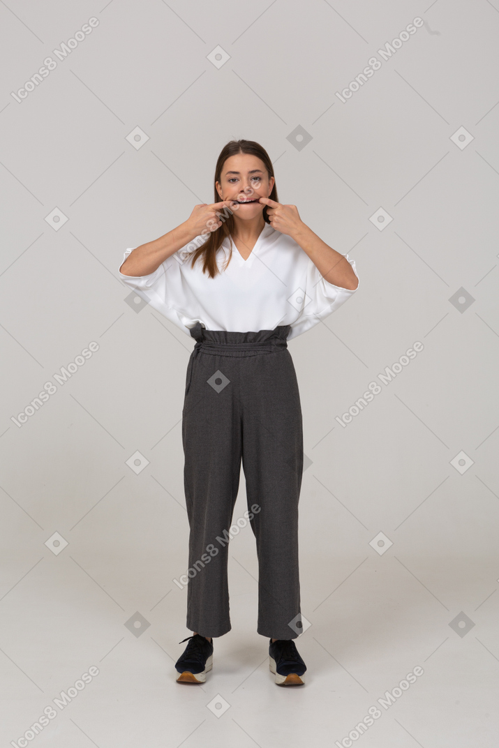 Vista frontal de una señorita haciendo muecas en ropa de oficina