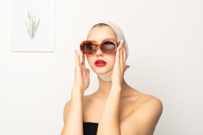 Jeune femme avec un bandage sur la tête portant des lunettes de soleil