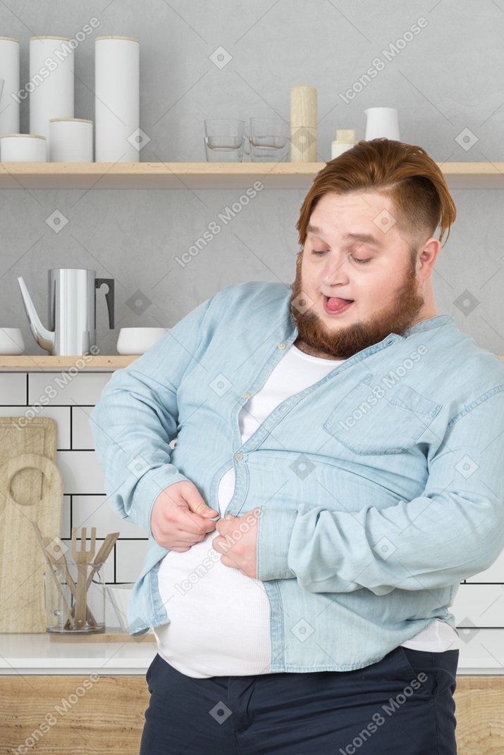 A fat man buttoning up his shirt