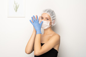 Frau in medizinischer maske mit gefalteten händen