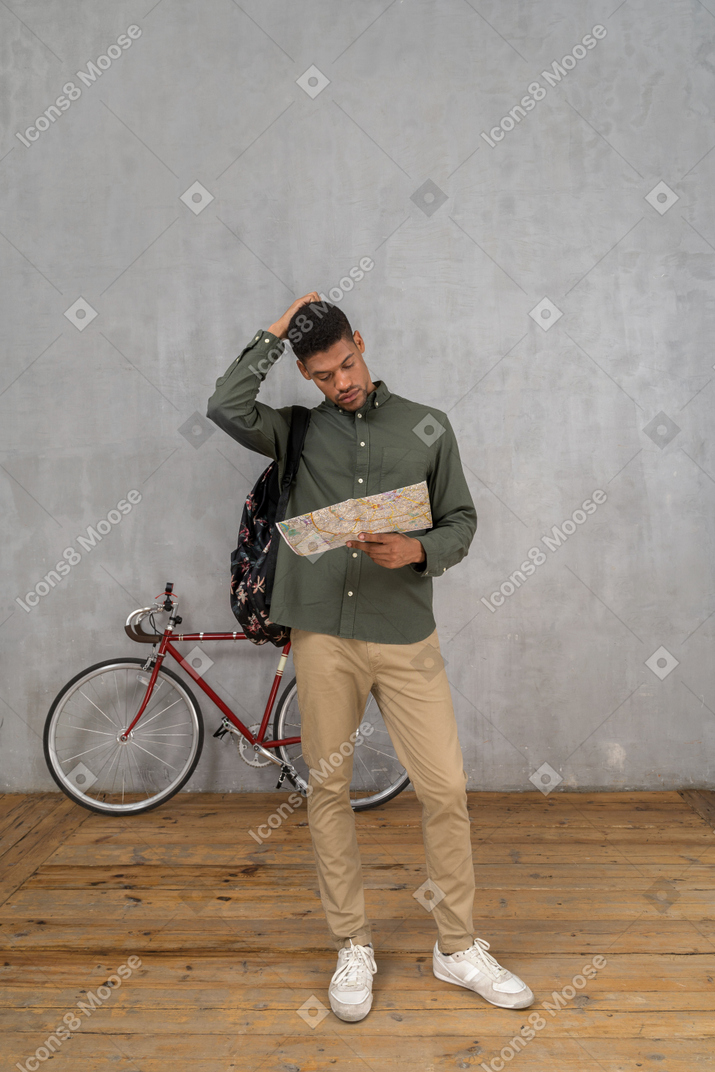 Front view of a man looking at a map in confusion