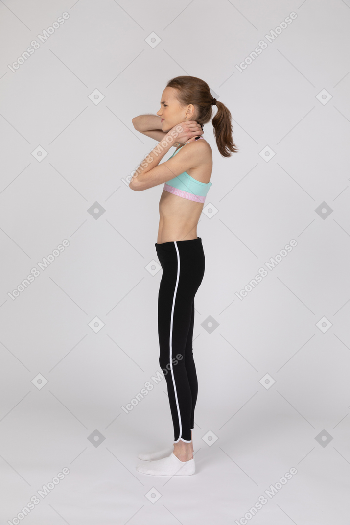 Teen girl in sportswear having neck pain