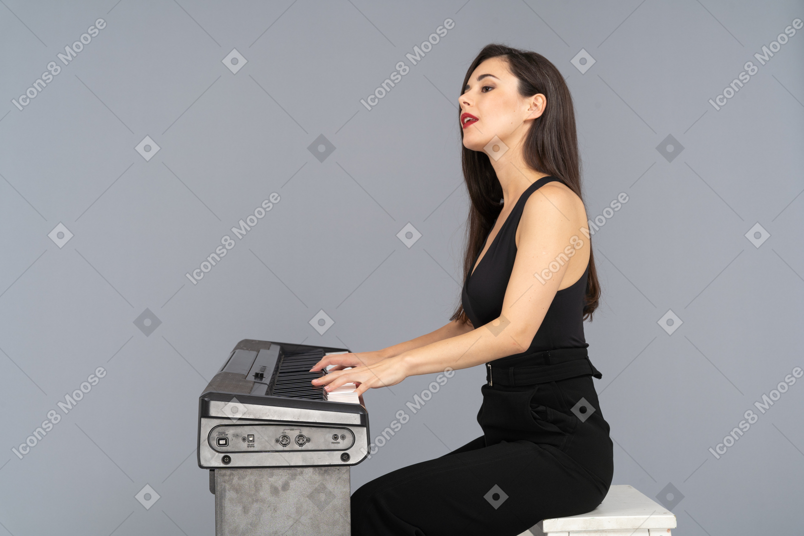 Vista lateral, de, un, señorita, en, traje negro, sentado, y, tocar el piano