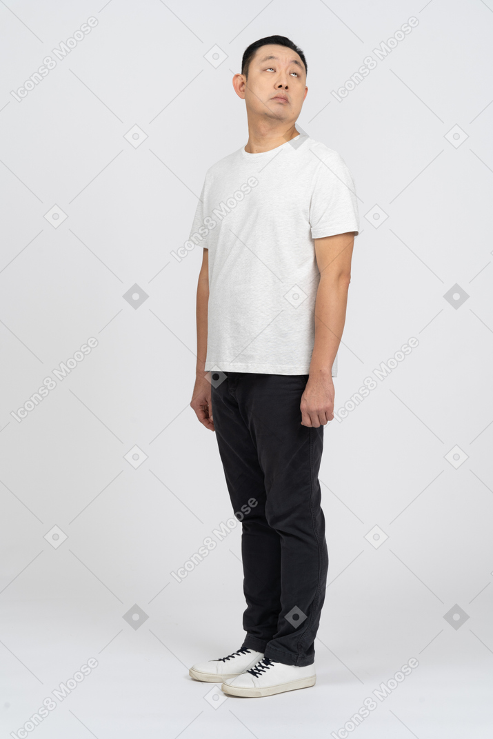 Man in casual clothes standing still and looking up