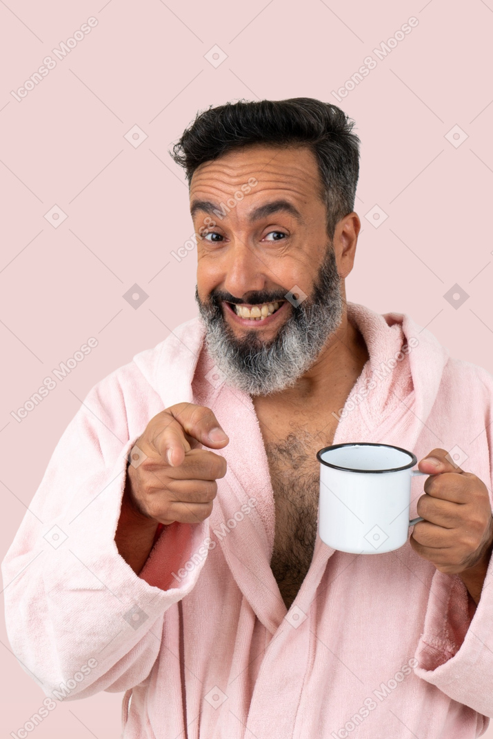 Un vieil homme tenant une tasse et souriant