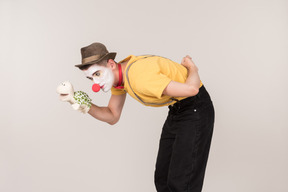 Bend male clown holding toy turtle