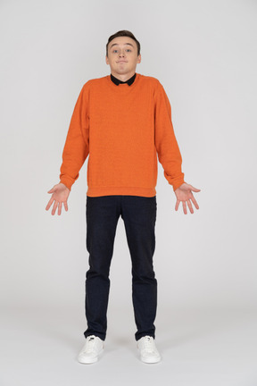 Young man in orange sweatshirt standing