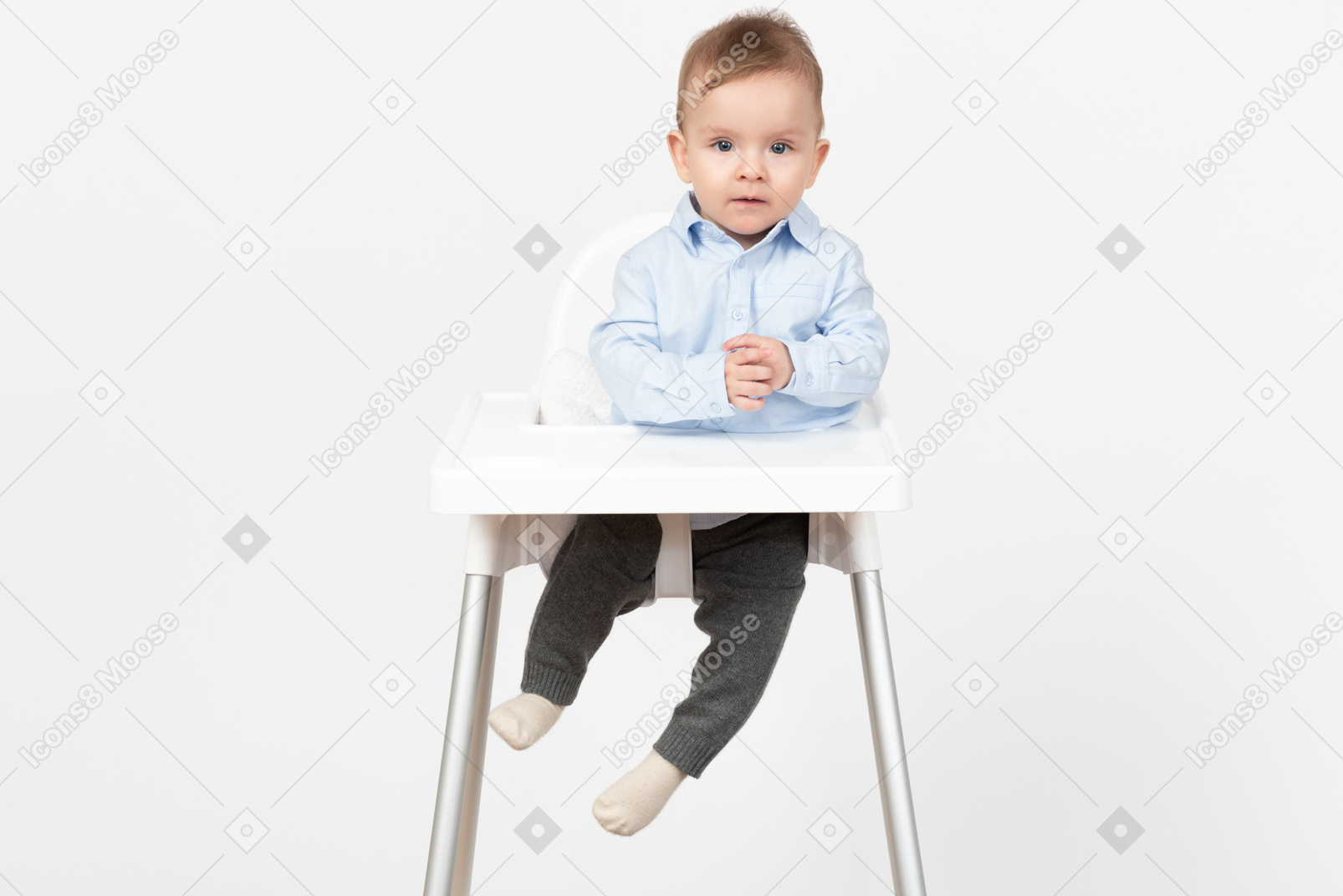 Adorable smiling baby boy sitting in highchair