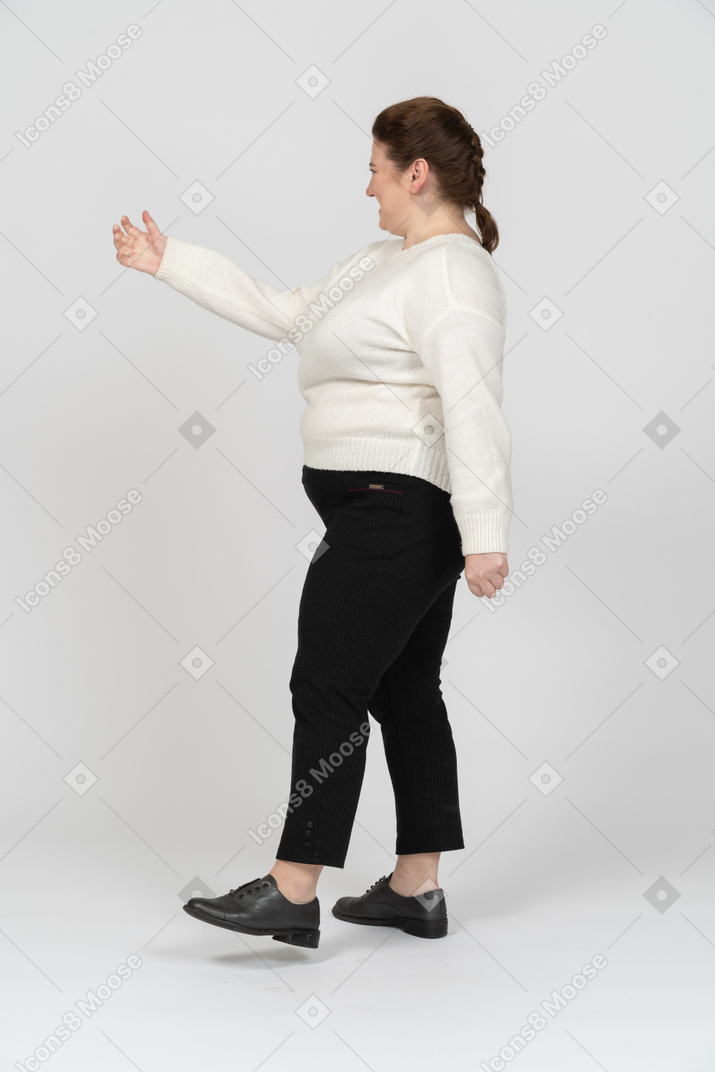 Plump woman in white sweater walking