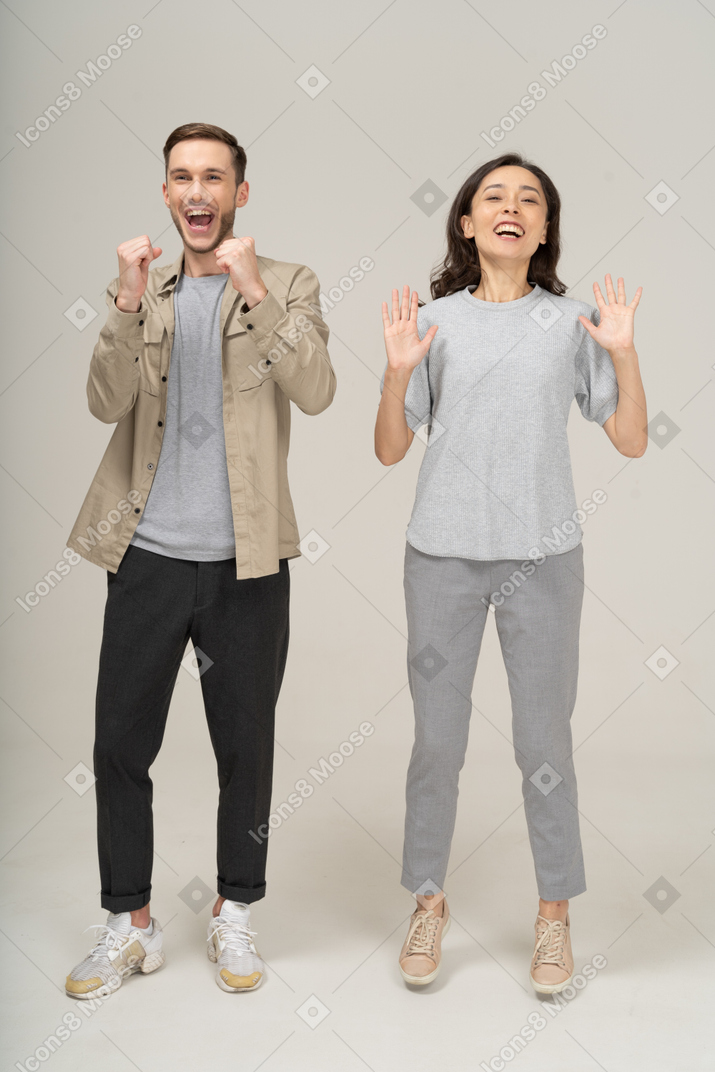 Радостная молодая пара аплодирует