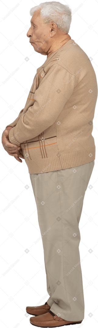 Vue latérale d'un vieil homme en vêtements décontractés faisant des grimaces
