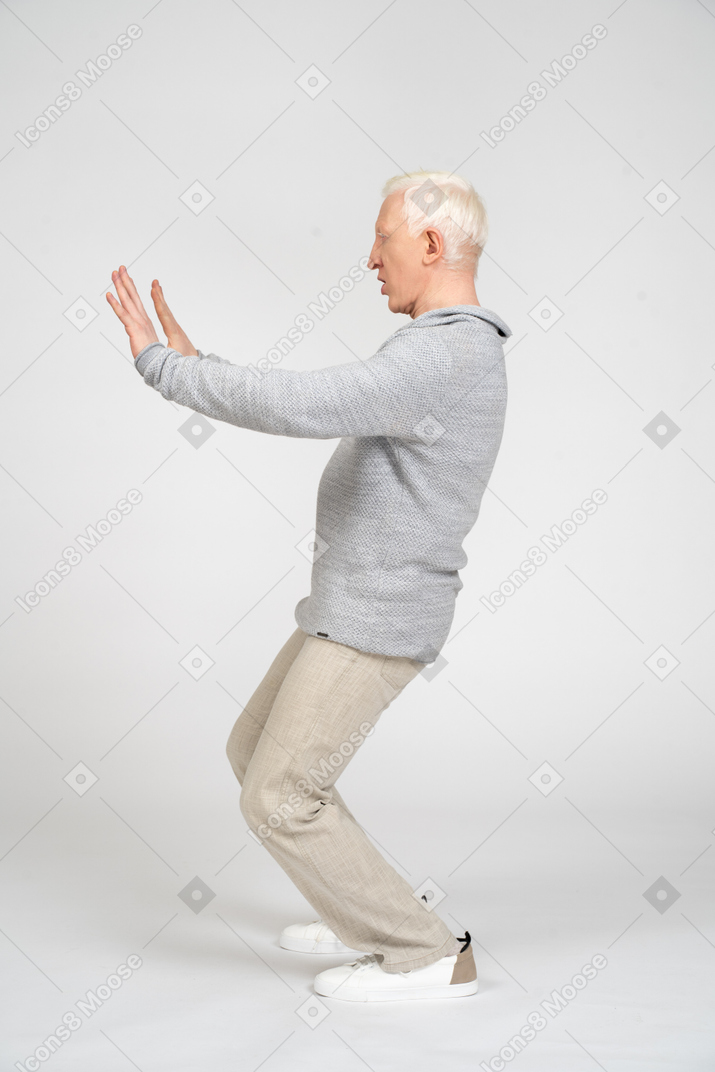 Vista lateral do homem mostrando o gesto de parada com as duas mãos