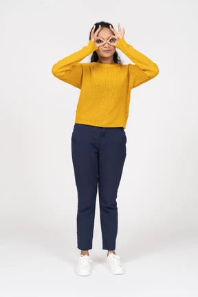 Front view of a girl in casual clothes looking through fingers