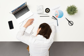 Um trabalhador de escritório feminino dormindo na mesa