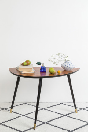 Books, pears, vintage vase with dried twig on vintage style coffee table