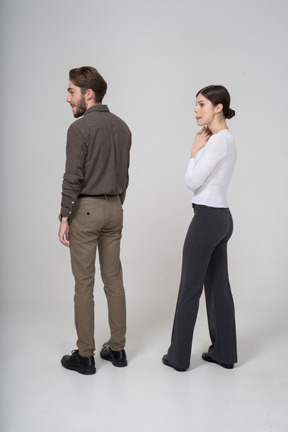 Trois quarts vue arrière d'un jeune couple en vêtements de bureau lécher les lèvres