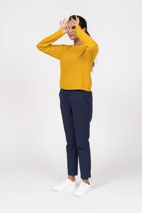 Side view of a girl in casual clothes looking through fingers