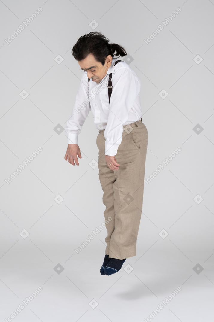 Middle-aged man in suspenders levitating