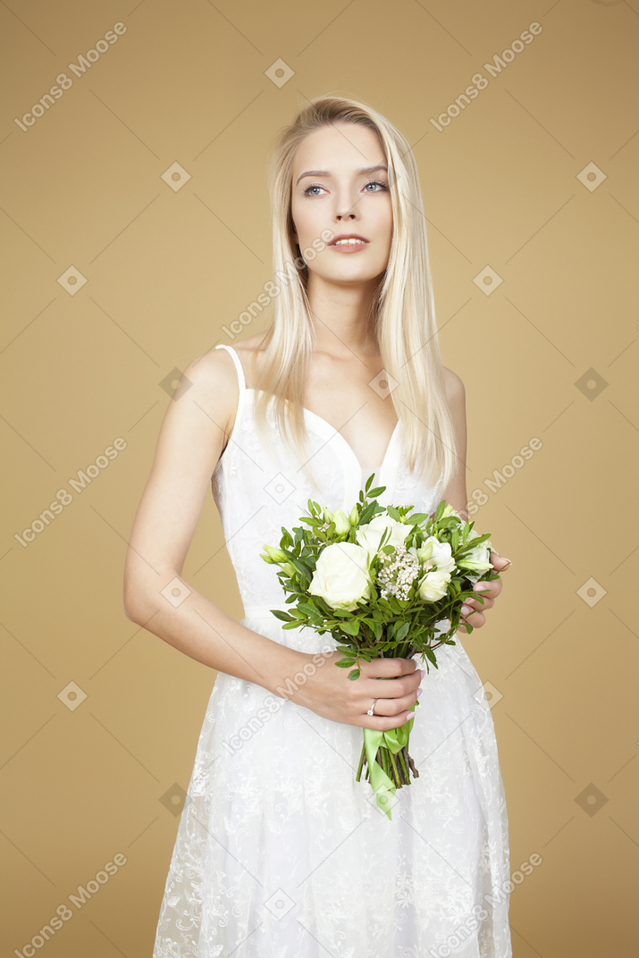 Linda jovem noiva segurando o buquê de flores brancas