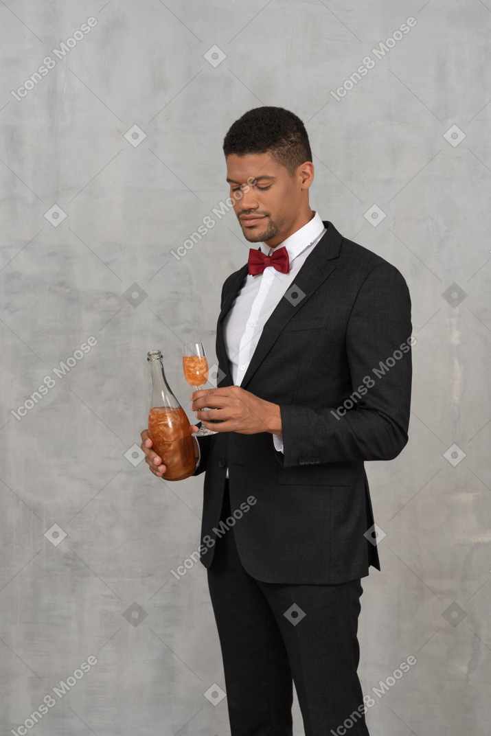Man in formal wear looking down at a glass of champagne