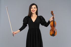 Vista frontal de uma violinista vestida de preto fazendo uma reverência