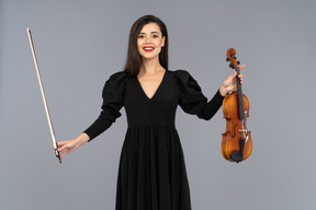 Front view of a female violin player in black dress making a bow