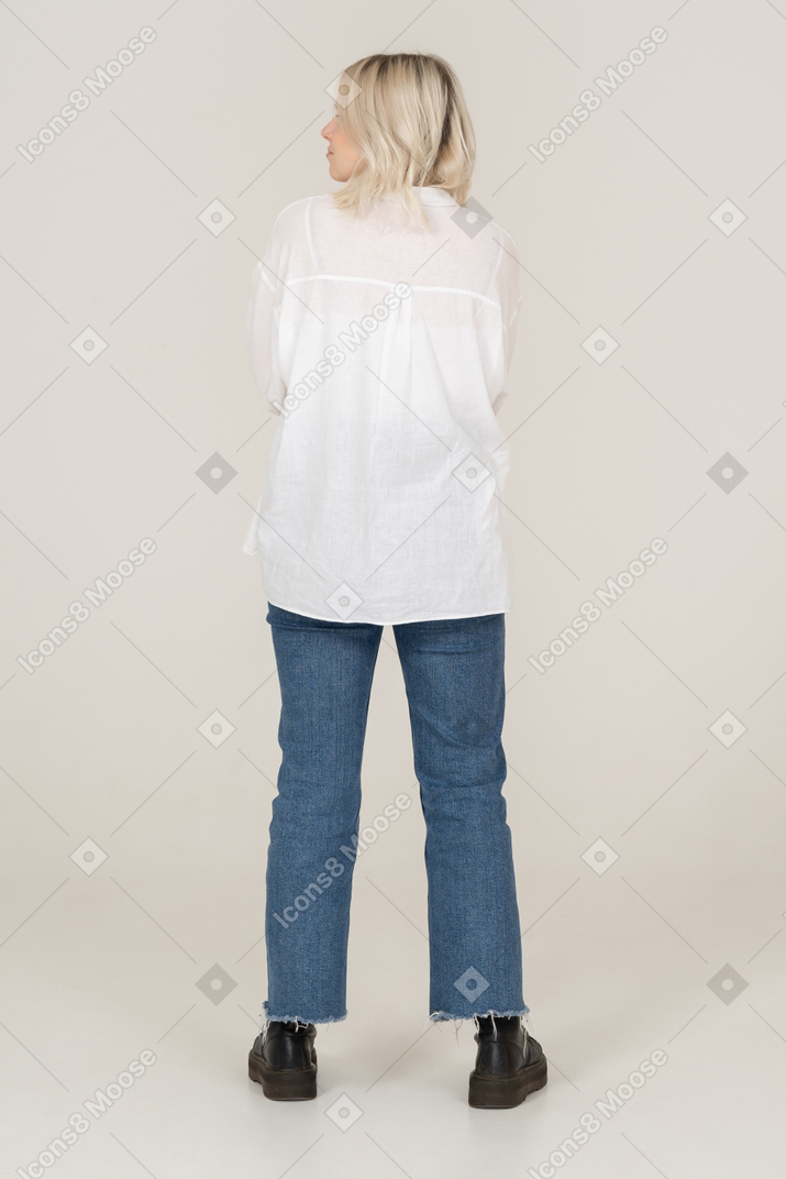 Vista traseira de uma mulher loira com roupas casuais olhando para o lado